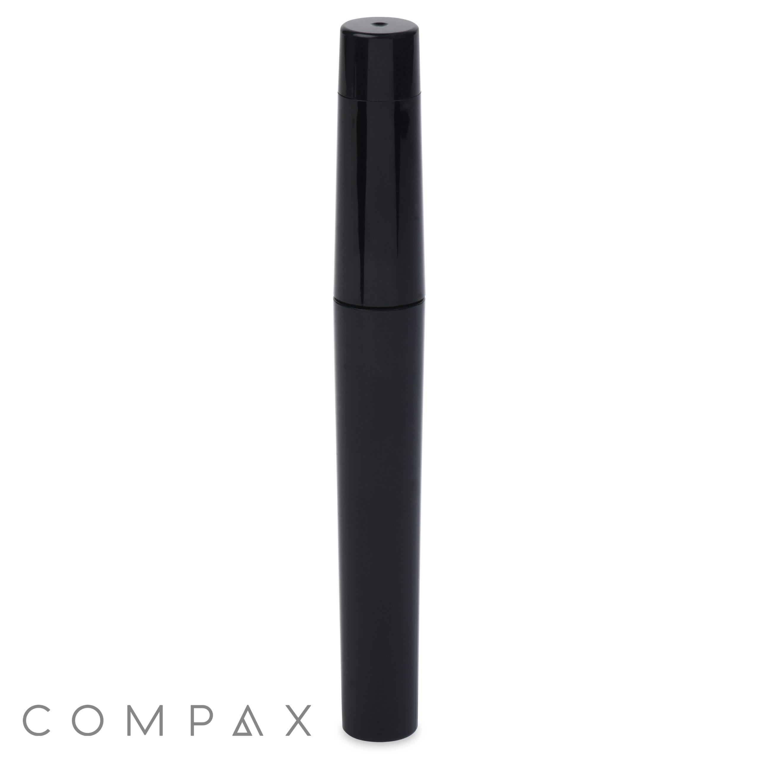 Black cylindrical mascara tube with a sleek design and a pointed cap, standing upright on a white background. The brand name "COMPAX" is featured at the bottom left corner of the image.