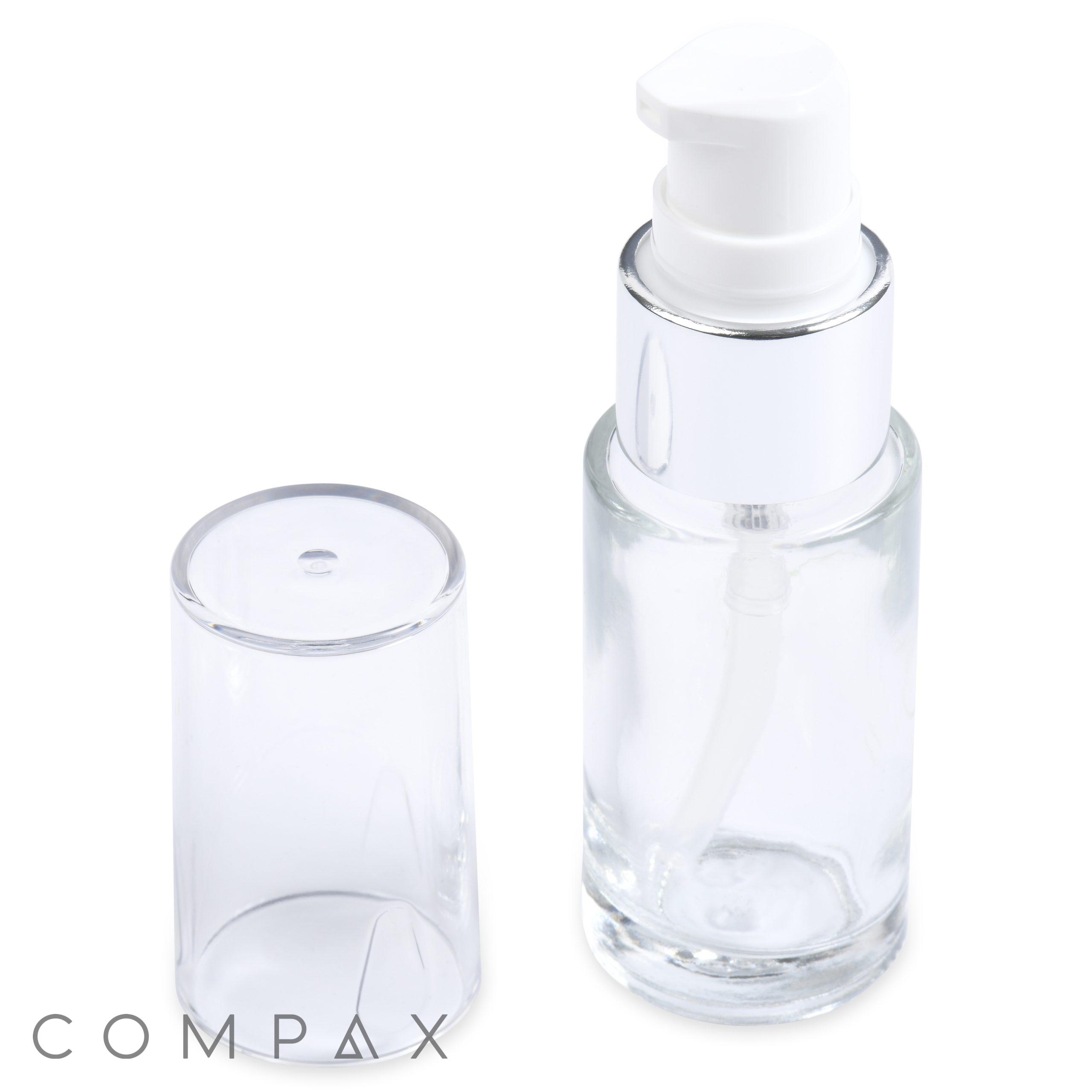 A 15mL Glass Cylinder Round Bottle featuring a shiny silver collar and a white pump dispenser, complemented by a transparent plastic cap standing beside it. The brand name "COMPAX" is visible at the bottom left corner.