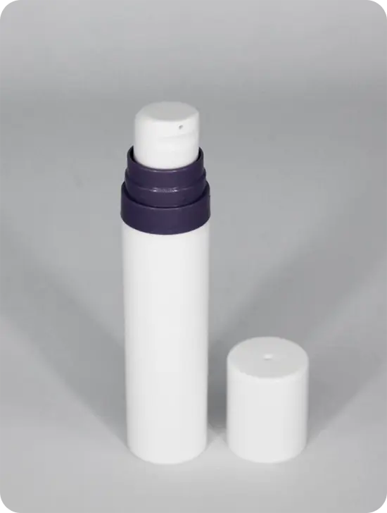 A white plastic pump bottle with a pump dispenser cap. The bottom of the dispenser cap is dark purple. The bottle's white cap is removed and placed beside the bottle.